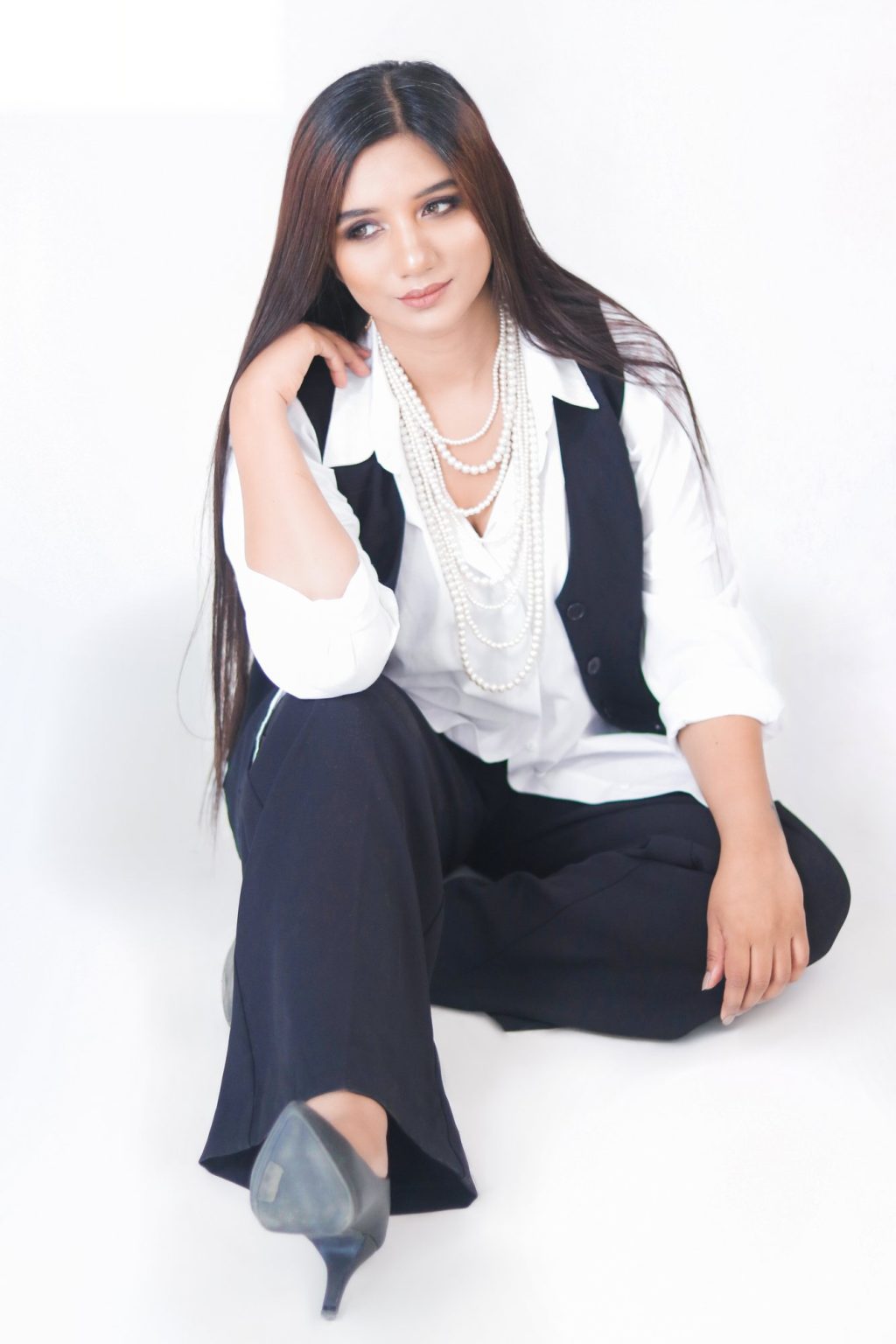 Sakshi Jethwani seated, in a white shirt and black waistcoat